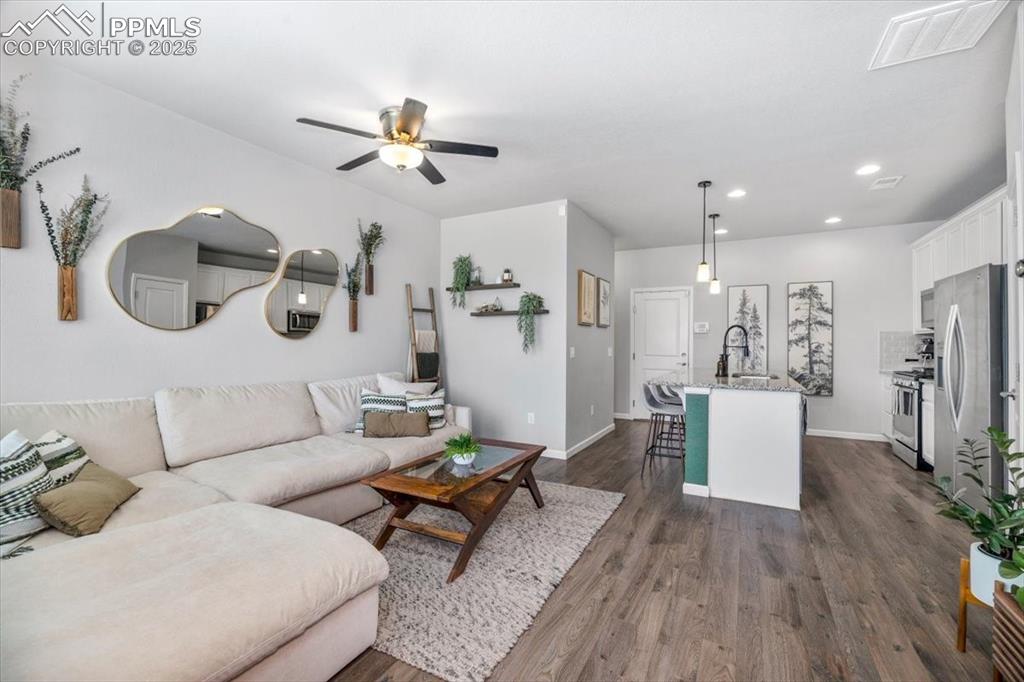 15446 West 64th Loop, Unit D Arvada, CO 80007 - Photo 4 of 22 a living room with furniture and kitchen view