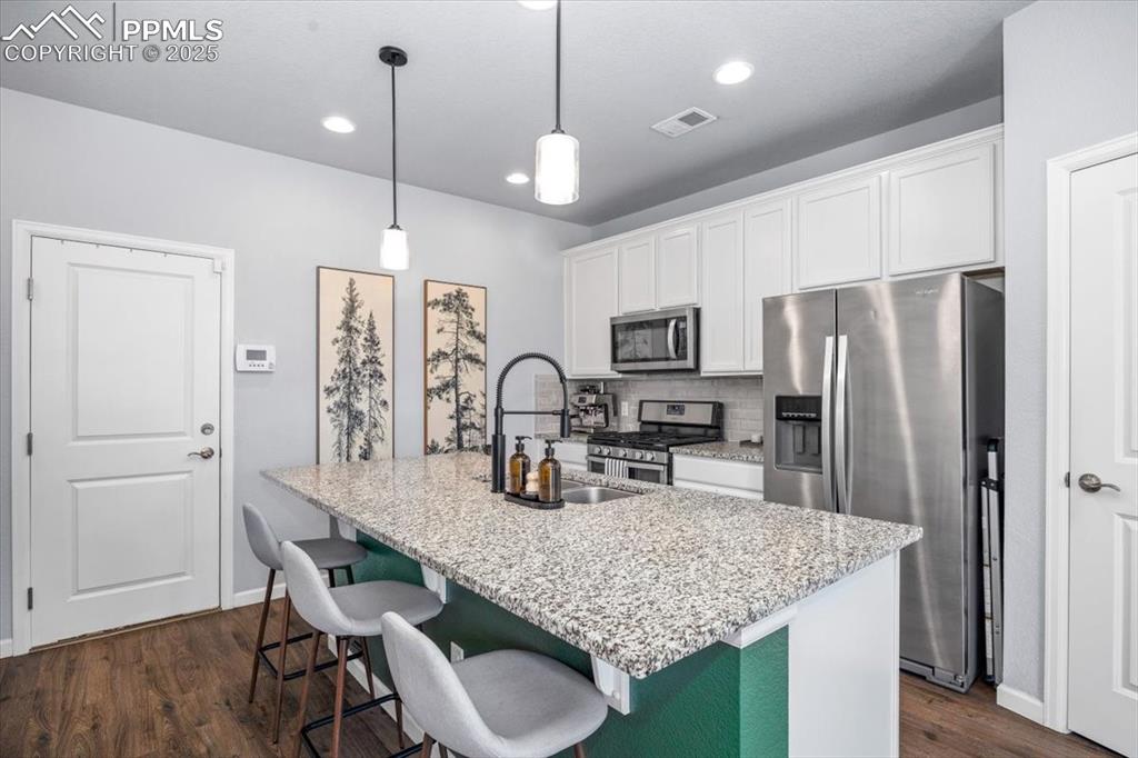 15446 West 64th Loop, Unit D Arvada, CO 80007 - Photo 7 of 22 a kitchen with stainless steel appliances granite countertop a sink refrigerator and microwave