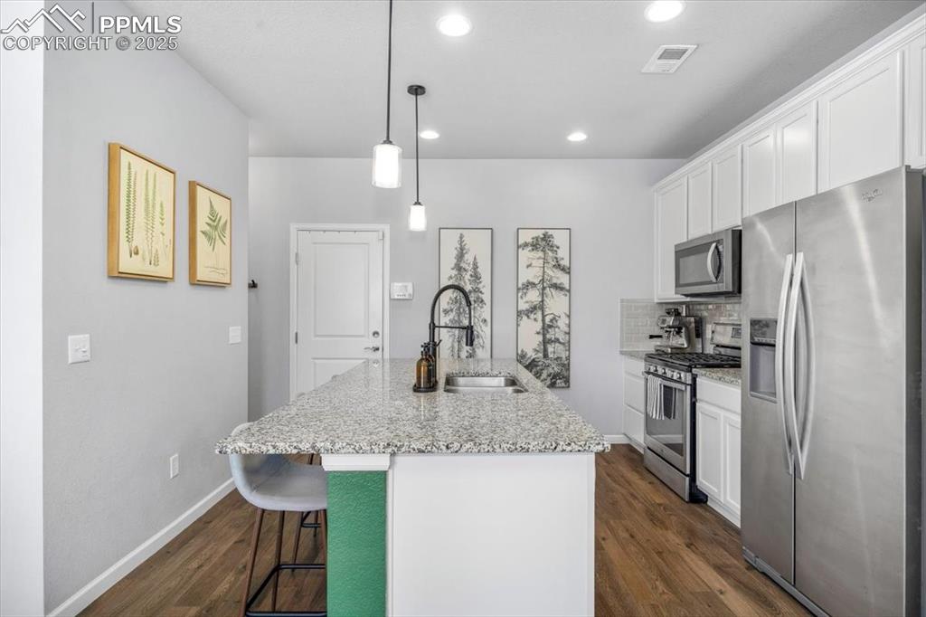 15446 West 64th Loop, Unit D Arvada, CO 80007 - Photo 8 of 22 a kitchen with stainless steel appliances granite countertop a sink refrigerator and microwave