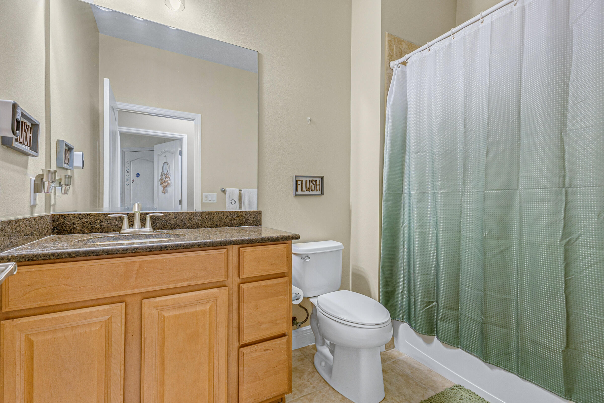 6002 Goleta Circle Melbourne, FL 32940 - Photo 22 of 45 a bathroom with a granite countertop sink a toilet and a mirror