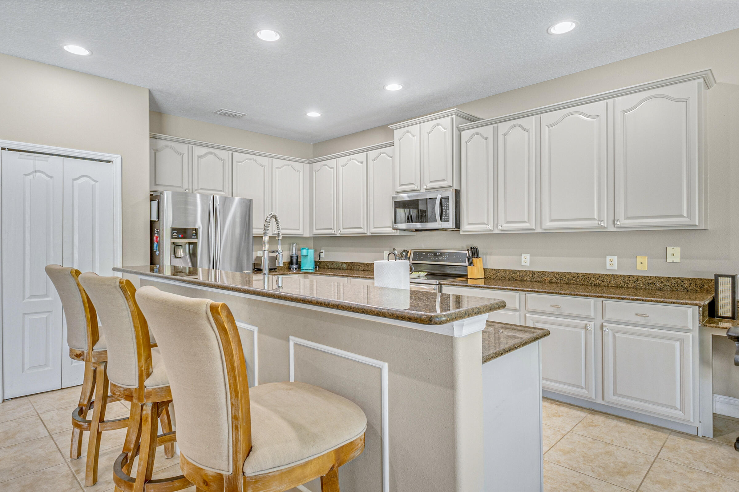 6002 Goleta Circle Melbourne, FL 32940 - Photo 5 of 45 a kitchen with stainless steel appliances granite countertop white cabinets a sink and a stove