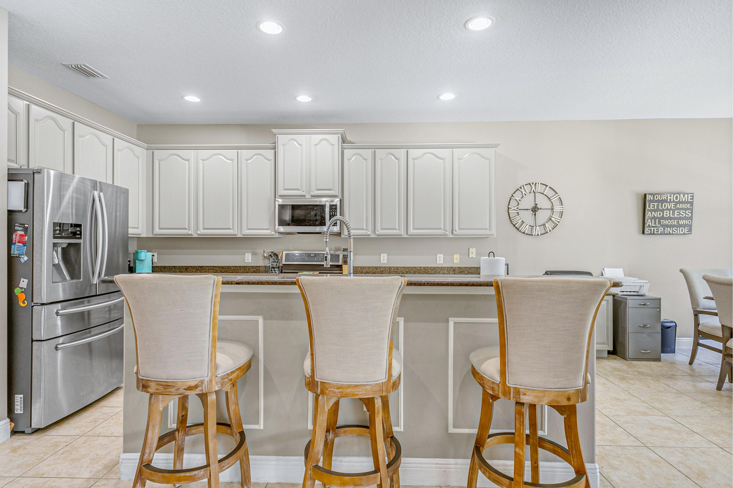 6002 Goleta Circle Melbourne, FL 32940 - Photo 9 of 45 a kitchen with stainless steel appliances granite countertop a dining table chairs and a refrigerator