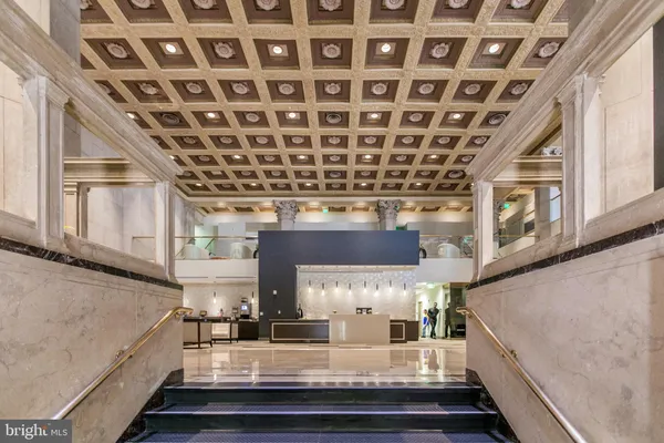 a living room with furniture a large window and kitchen view