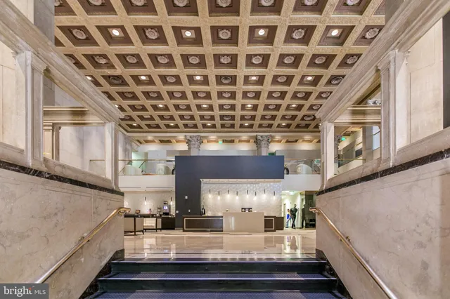 a living room with furniture a large window and kitchen view