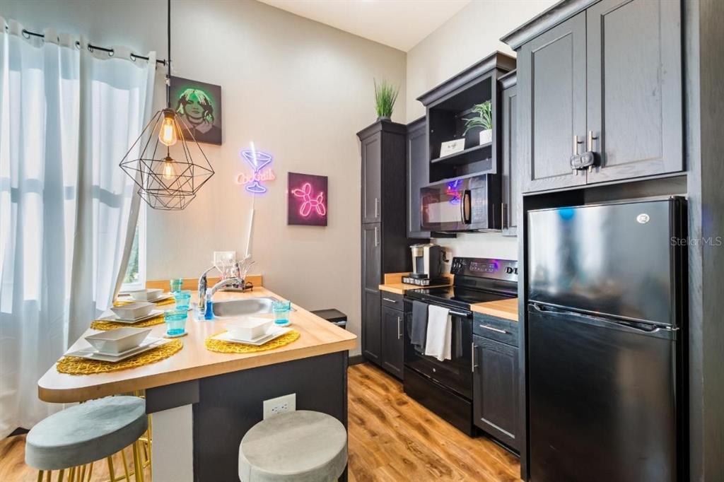 2004 North Howard Avenue, Unit 203 Tampa, FL 33607 - Photo 16 of 16 a kitchen with stainless steel appliances granite countertop a refrigerator and a stove top oven