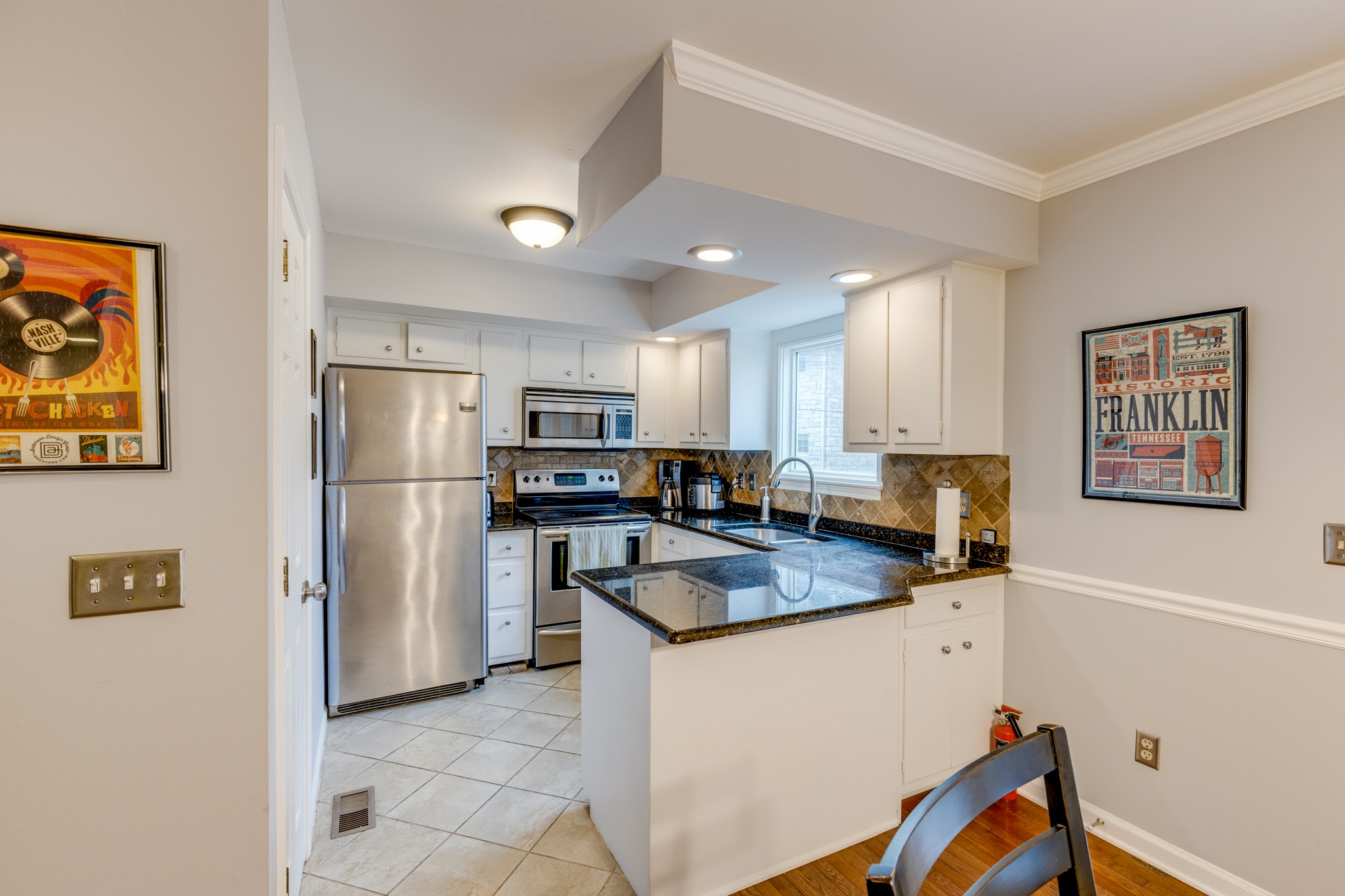 a kitchen with stainless steel appliances granite countertop a refrigerator sink and microwave