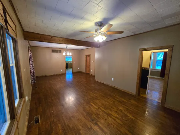 an empty room with wooden floor and entrance