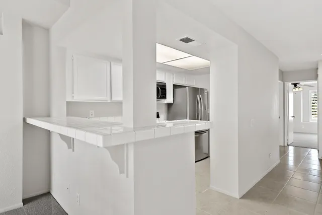 a kitchen with stainless steel appliances granite countertop a sink and a refrigerator