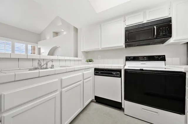 a kitchen with stainless steel appliances granite countertop a stove microwave and sink
