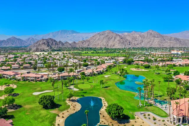 a view of a lush green field with mountains in the background