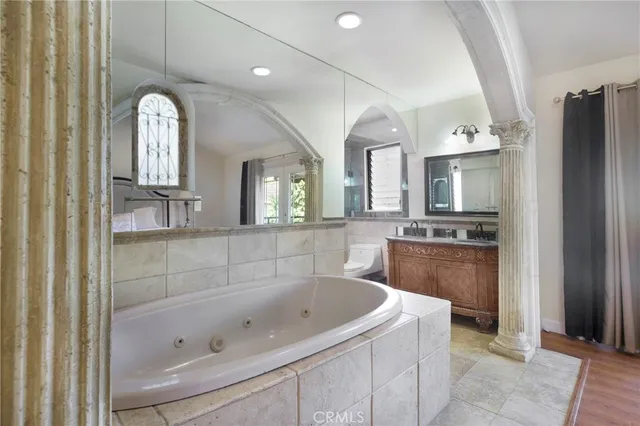 a spacious bathroom with a bathtub sink and mirror