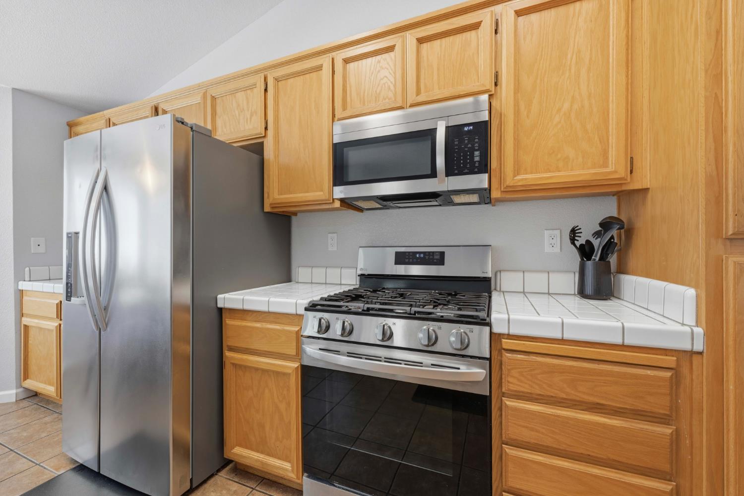 5013 Charter Road Rocklin, CA 95765 - Photo 14 of 35 a kitchen with stainless steel appliances granite countertop a stove microwave and refrigerator