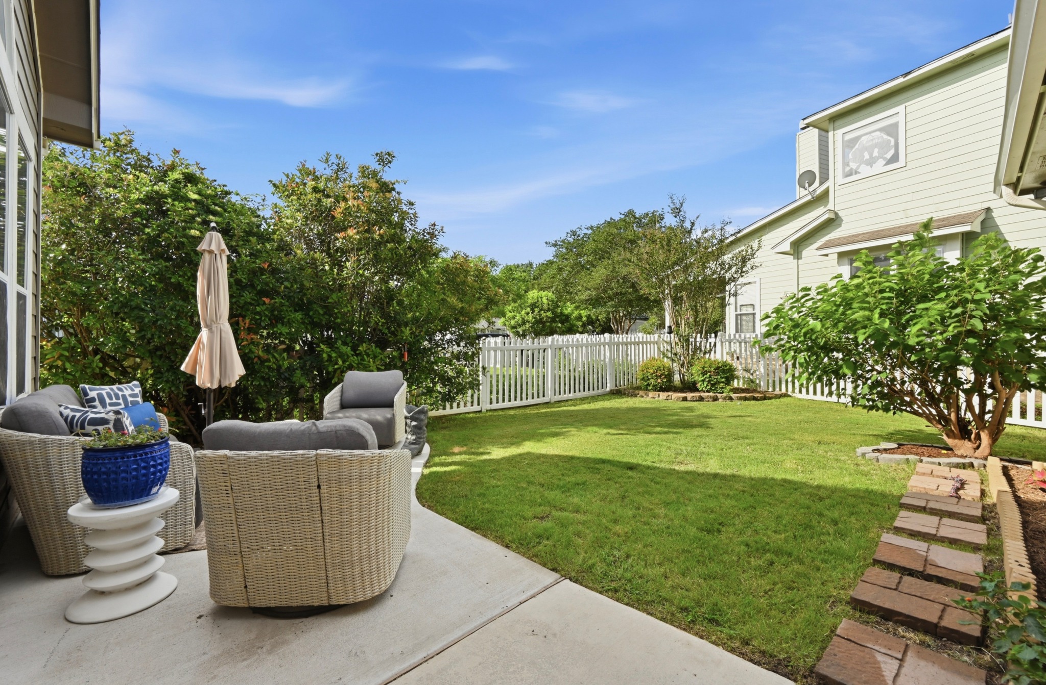 5888 Fergus Kyle, TX 78640 - Photo 28 of 40 An inviting outdoor patio with ample seating overlooks a verdant lawn enclosed by a classic picket fence.
