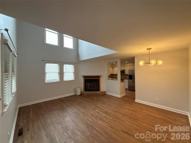 an empty room with windows and fireplace
