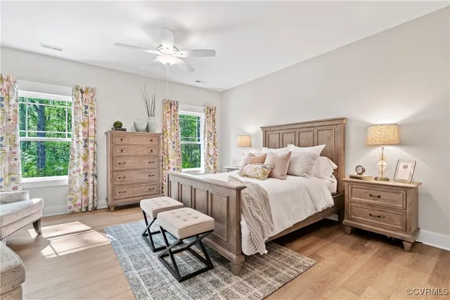 a spacious bedroom with a bed a couch and dresser