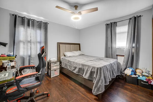 a bedroom with a bed wooden floor and window