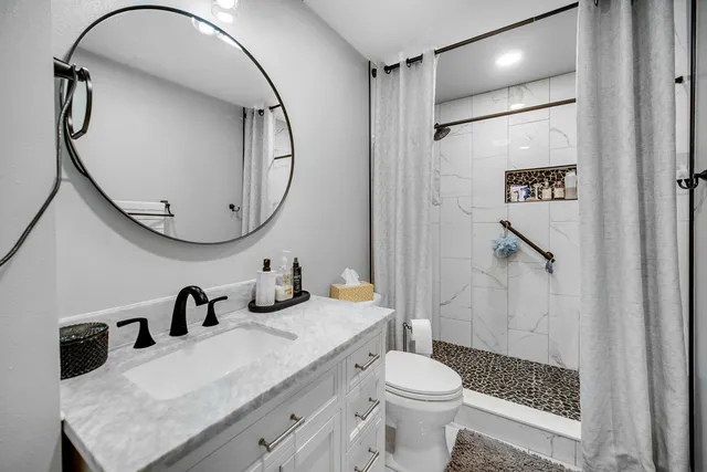 a bathroom with a sink a toilet and a mirror