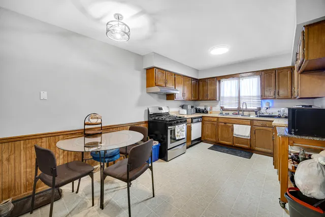 a kitchen with a dining table chairs and refrigerator