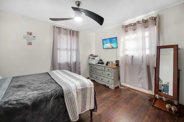 a bedroom with a bed and wooden floor