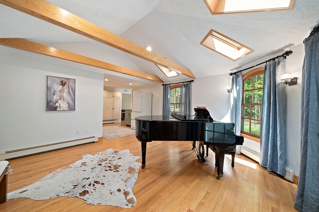 6 Garfield Street Lexington, MA 02421 - Photo 20 of 40 a living room with furniture a dining table and a floor to ceiling window with wooden floor