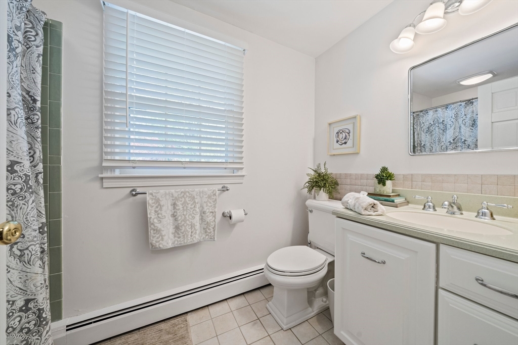 6 Garfield Street Lexington, MA 02421 - Photo 31 of 40 a bathroom with a toilet sink vanity and mirror