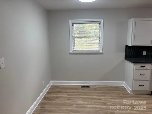 a view of a room with wooden floor and flat screen tv