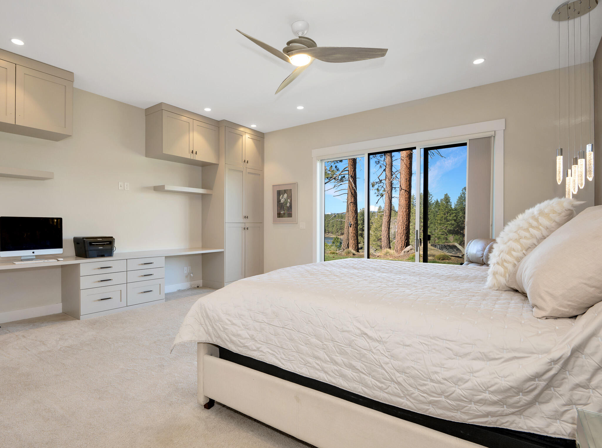 60871 River Rim Drive Bend, OR 97702 - Photo 23 of 42 a bedroom with a large bed and a chandelier
