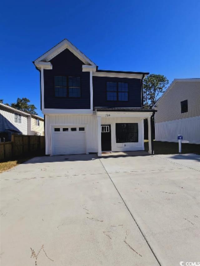Tbd 67th Avenue North Myrtle Beach, SC 29572 - Photo 17 of 31 View of front of property with board and batten siding, concrete driveway, fence, and an attached garage