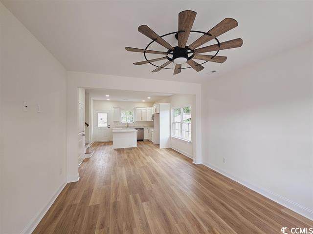 Tbd 67th Avenue North Myrtle Beach, SC 29572 - Photo 21 of 31 Unfurnished living room with light wood-type flooring, ceiling fan, baseboards, and a wealth of natural light