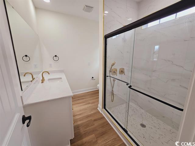 Tbd 67th Avenue North Myrtle Beach, SC 29572 - Photo 26 of 31 Bathroom featuring toilet, a marble finish shower, wood finished floors, and vanity