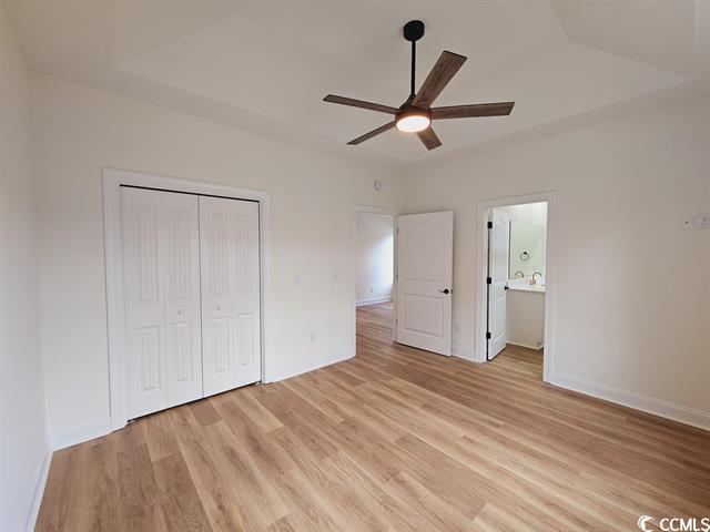 Tbd 67th Avenue North Myrtle Beach, SC 29572 - Photo 27 of 31 Unfurnished bedroom with ceiling fan, a closet, light wood-style flooring, and baseboards
