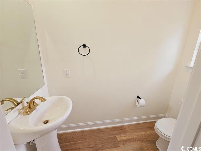 Tbd 67th Avenue North Myrtle Beach, SC 29572 - Photo 29 of 31 Bathroom featuring baseboards, a sink, toilet, and wood finished floors