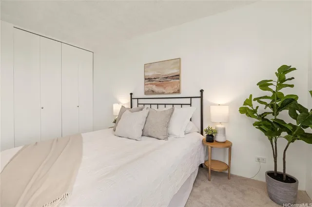 a bedroom with a bed potted plant and a window