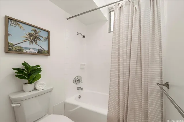 a white toilet sitting next to a bath tub