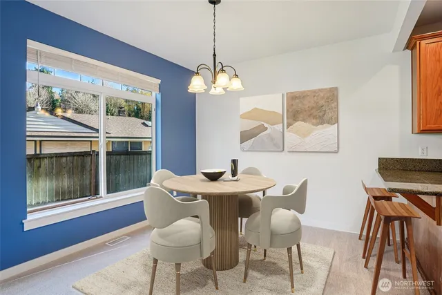 a dining room with furniture a chandelier and wooden floor