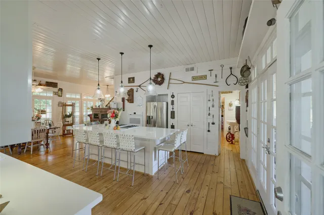 a large white kitchen with lots of counter space and wooden floor