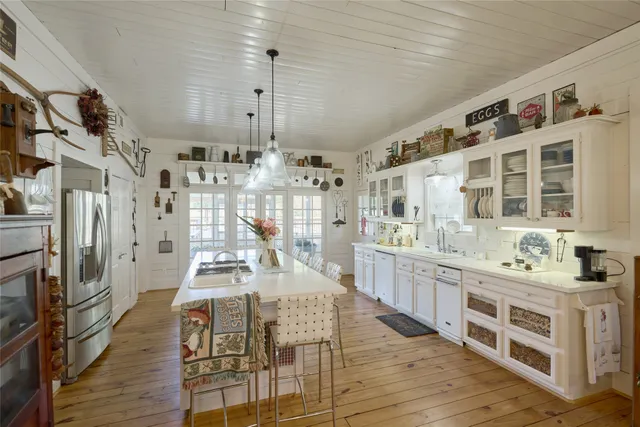 a large kitchen with stainless steel appliances kitchen island granite countertop a lot of counter space and wooden floor