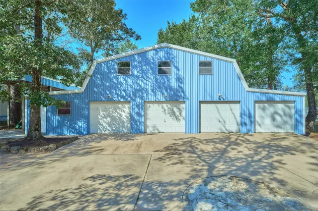 a view of a house with a yard and large tree