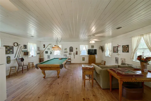 a living room with furniture pool table and chairs