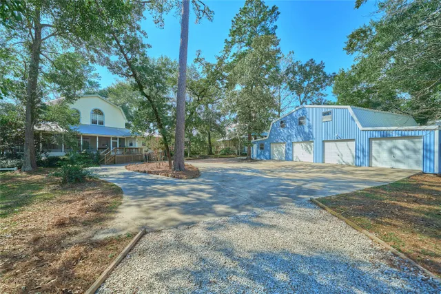 a front view of a house with a yard and large trees