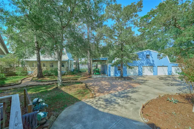 a view of a house with a yard and large tree