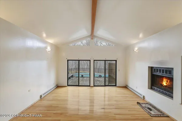 a view of an empty room with a fireplace and a window
