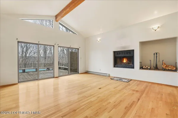 a view of an empty room with a fireplace and a window