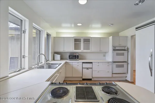 a kitchen with a sink a stove and cabinets