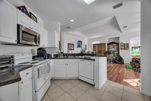 a living room with furniture and a dining table with kitchen view