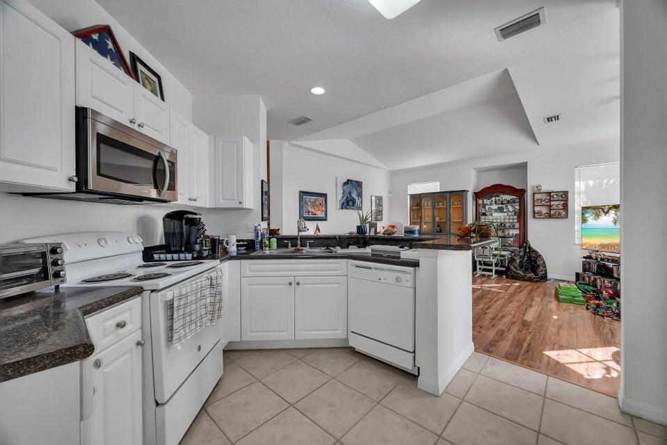 360 Southeast Rogers Court Stuart, FL 34994 - Photo 12 of 25 a kitchen with stainless steel appliances granite countertop a sink and dishwasher a stove top oven with wooden floor