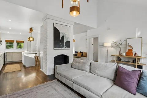 a living room with furniture a fireplace and a chandelier
