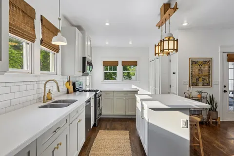 a kitchen with stainless steel appliances a refrigerator sink and cabinets