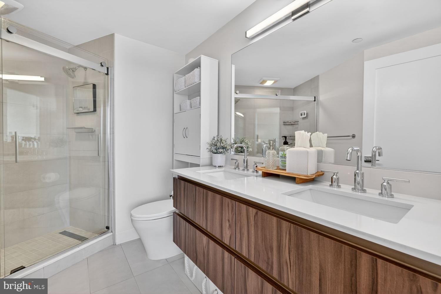 37 L Street Southeast, Unit 802 Washington, DC 20003 - Photo 10 of 23 a bathroom with a double vanity sink mirror double shower and a toilet