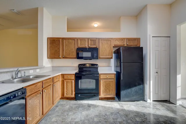 a kitchen with stainless steel appliances granite countertop a refrigerator stove and sink